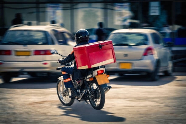Woman delivers courier on bike without helmet, toddler on lap - News Karnataka