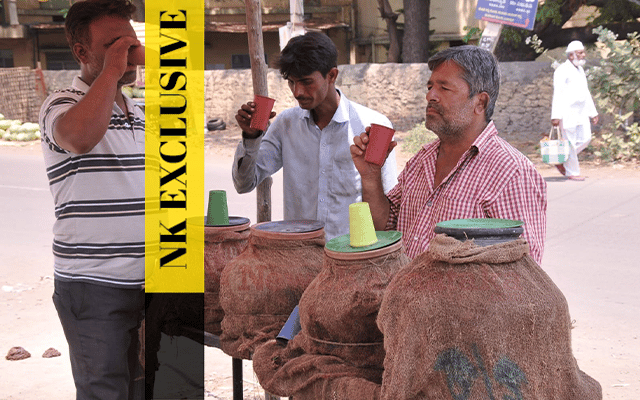 Men drinking water due to extreme heat, Vijayapura