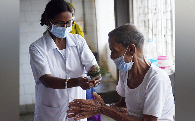 A health worker gives a rose to a patient on World Tuberculosis Day